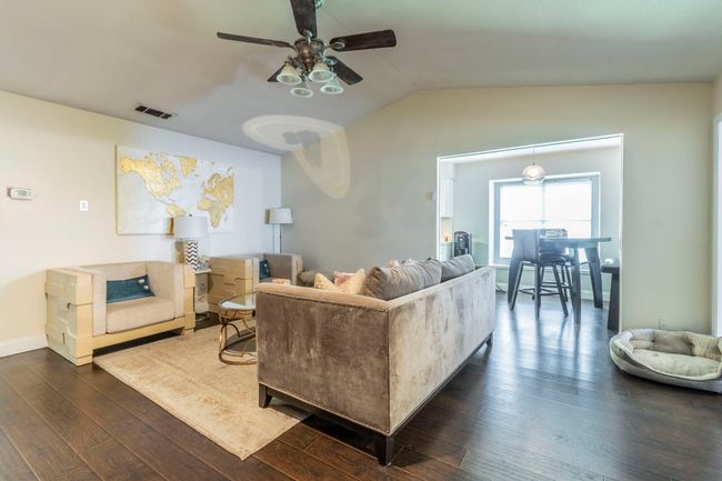 Living area with a ceiling fan, dark wood-type flooring, vaulted ceiling, and baseboards | Image 6