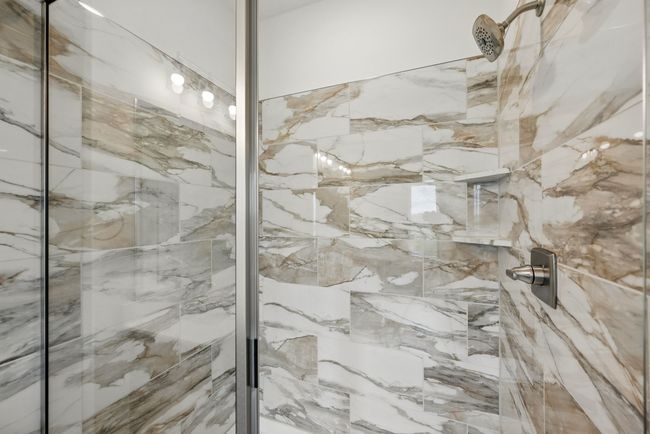 This spacious walk in owner's shower features gorgeous designer tile! | Image 15