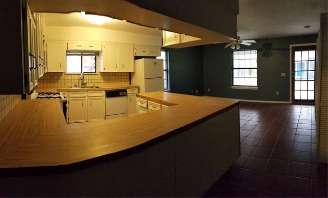 Kitchen featuring refrigerator, dishwashing machine, a sink, a ceiling fan, and healthy amount of natural light | Image 18