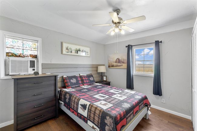 Bedroom with ceiling fan, baseboards, and dark wood-style floors | Image 12