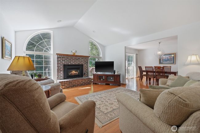 Main living with propane fireplace and plenty of windows. | Image 9