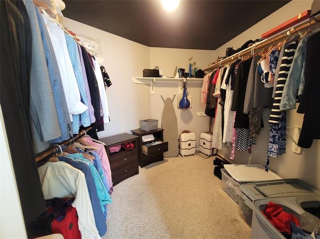 This spacious walk-in closet features ample hanging space, shelving, and storage solutions, providing excellent organization for clothing and accessories. | Image 22