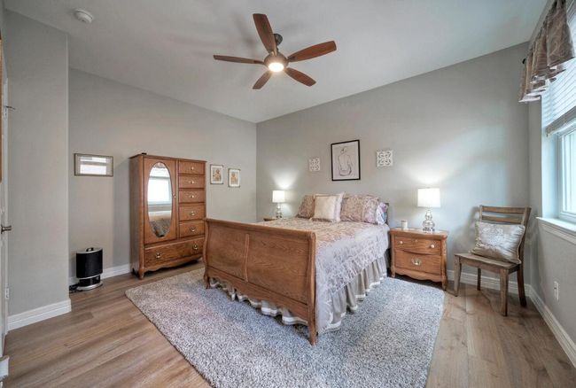 Bedroom featuring a ceiling fan, light wood finished floors, and baseboards | Image 25