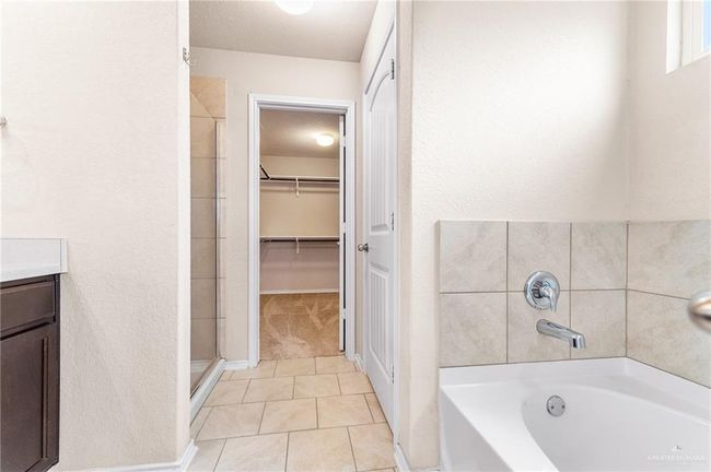 Bathroom with a garden tub, tile patterned floors, a shower stall, a spacious closet, and vanity | Image 15