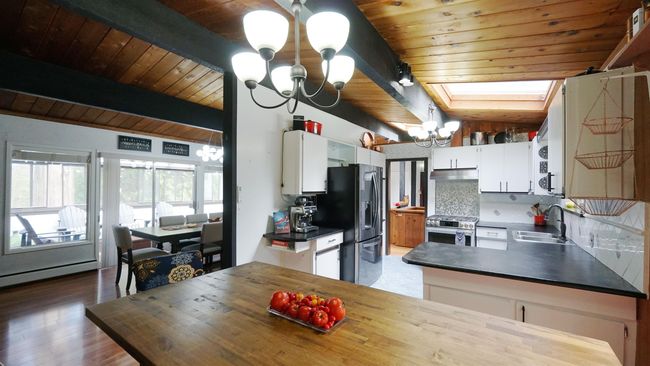 Kitchen featuring dark countertops, white cabinetry, and a notable chandelier | Image 7