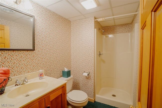 Bathroom with walk in shower, vanity, and wallpapered walls | Image 32