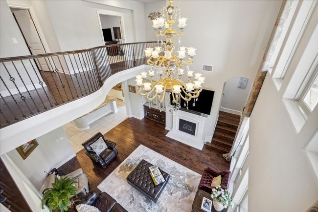 Living area with stairs, visible vents, arched walkways, and a chandelier | Image 19