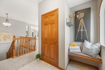 Bench and coat closet in the tiled entryway | Image 3