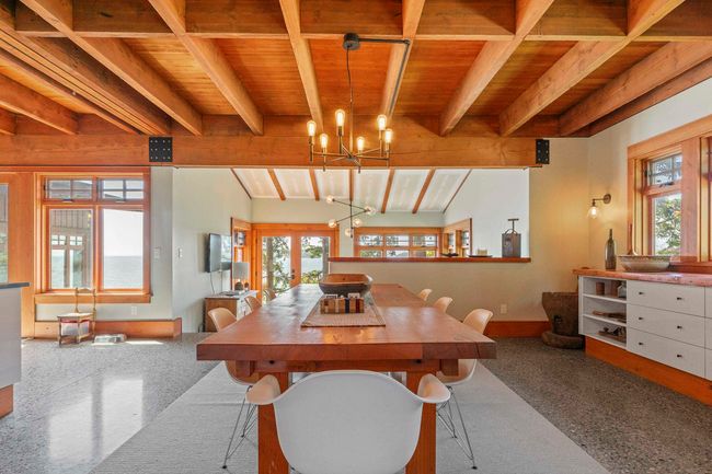 Dining room featuring wooden ceiling with exposed beams, baseboards, a chandelier, and plenty of natural light | Image 12