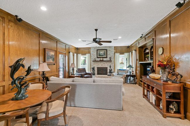 Spacious family room featuring a built-in entertainment center and cozy stone fireplace creates a warm, sophisticated atmosphere while providing both style and functionality for comfortable family living. | Image 11