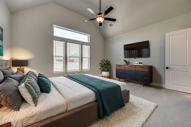 Bedroom featuring high vaulted ceiling, light colored carpet, a ceiling fan, visible vents, and baseboards | Image 10