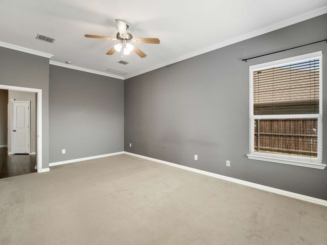 Carpeted spare room with a ceiling fan and crown molding | Image 23