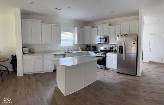 kitchen featuring white cabinets, visible vents, appliances with stainless steel finishes, and a sink | Image 11