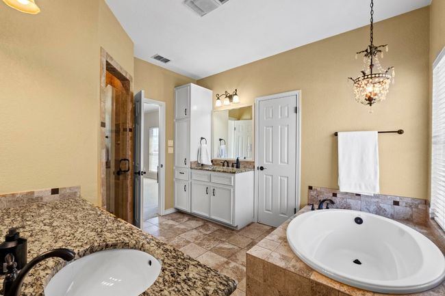 Full bathroom featuring vanity, a garden tub, visible vents, and a stall shower | Image 24