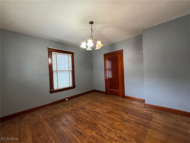 Unfurnished room featuring baseboards, hardwood / wood-style floors, and an inviting chandelier | Image 14