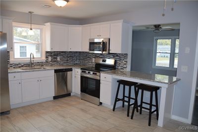 Kitchen with a wealth of natural light, white cabinetry, sink, and appliances with stainless steel finishes | Image 1