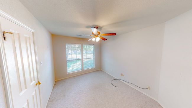 Empty room featuring a ceiling fan, light colored carpet, and a textured ceiling | Image 6
