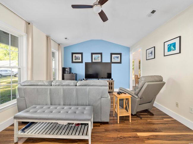 Living area with a ceiling fan, vaulted ceiling, and a wealth of natural light | Image 8