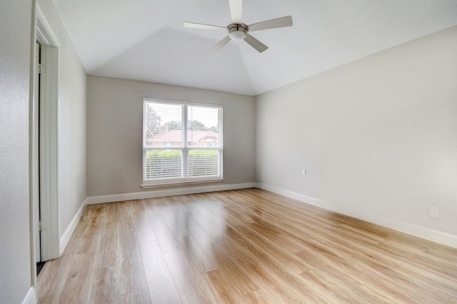 Unfurnished room featuring light wood finished floors, ceiling fan, and lofted ceiling | Image 13