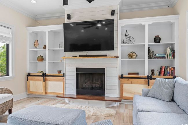 Living room with ornamental molding, wood finished floors, a fireplace with raised hearth, and recessed lighting | Image 14