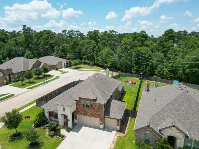 Discover this charming one and a half story brick and stone home with a spacious three-car garage. Nestled in a peaceful suburban neighborhood, it boasts a well-maintained front yard and a lush, expansive backyard perfect for outdoor fun. Surrounded by greenery, this home offers both privacy and tranquility. | Image 40