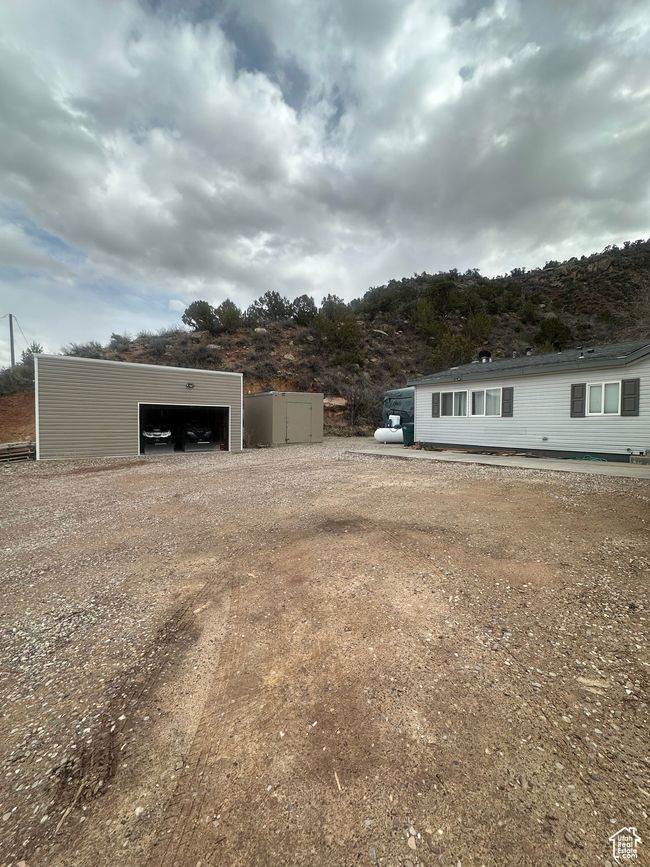 View of yard featuring driveway, an outbuilding, and a garage | Image 21