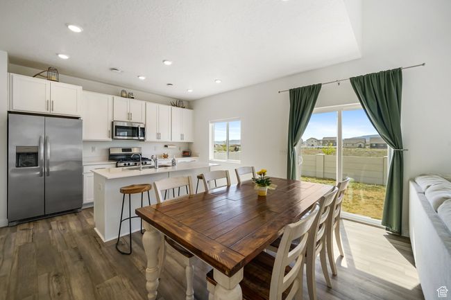 Dining room with wood finished floors and recessed lighting | Image 12
