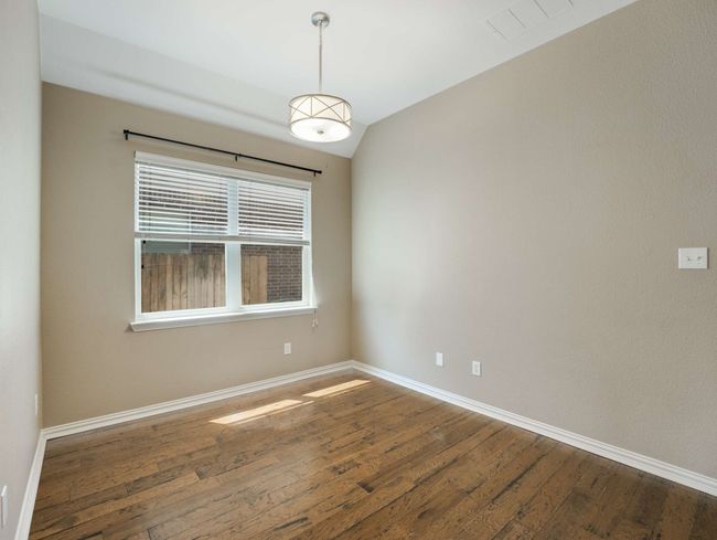 Empty room with wood finished floors and lofted ceiling | Image 27