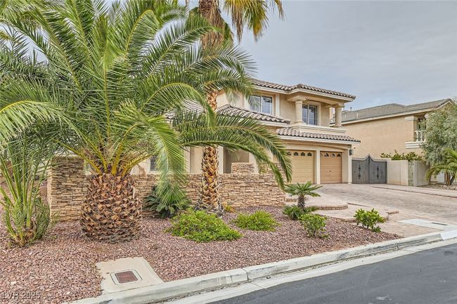 Mediterranean / spanish-style house with an attached garage, concrete driveway, a tiled roof, and stucco siding | Image 52