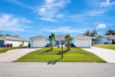 Ranch-style home featuring a garage and a front yard | Image 1