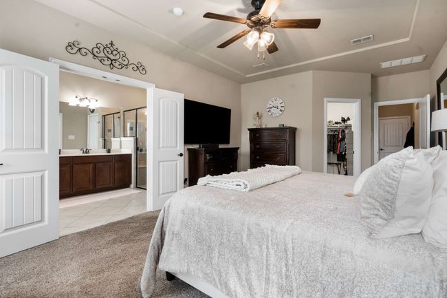 Bedroom featuring light tile patterned flooring, a spacious closet, a sink, light colored carpet, and a closet | Image 17