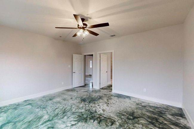 Empty room featuring concrete floors, visible vents, baseboards, and a ceiling fan | Image 19