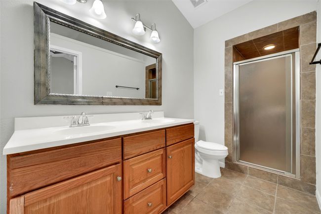 Full bath featuring double vanity, a shower stall, and tile patterned floors | Image 16