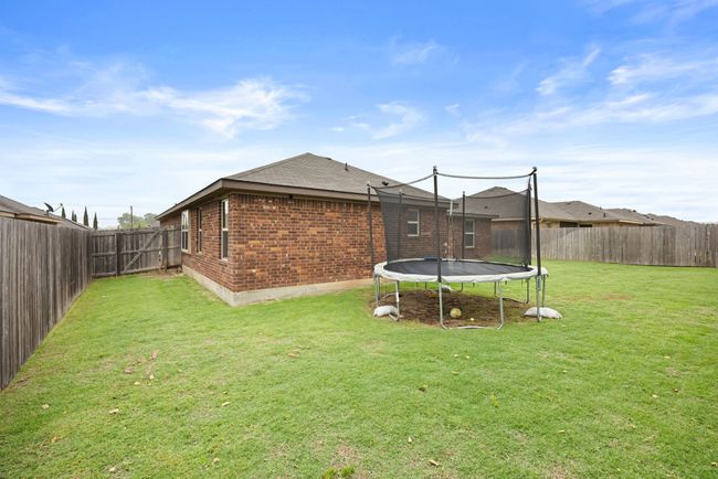 Fenced backyard with a trampoline | Image 28