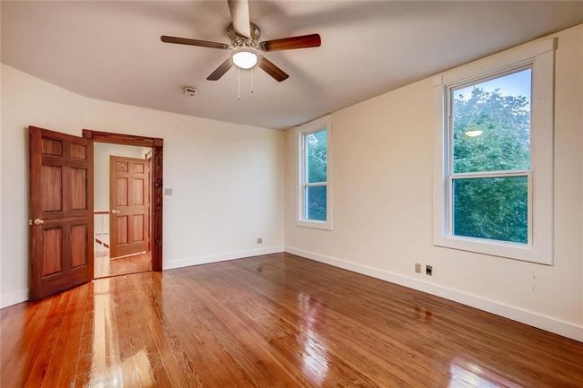 Spare room featuring wood finished floors, baseboards, and ceiling fan | Image 21