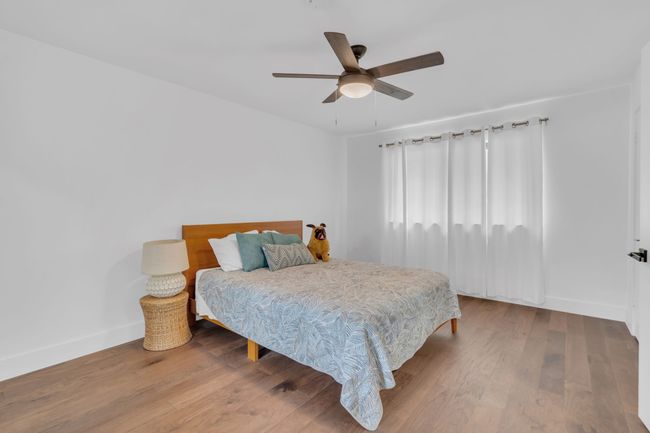 Bedroom featuring baseboards, a ceiling fan, and wood finished floors | Image 31