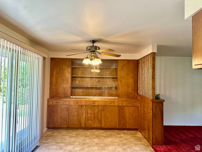 Unfurnished dining area with a ceiling fan and a built in china cabinet | Image 8