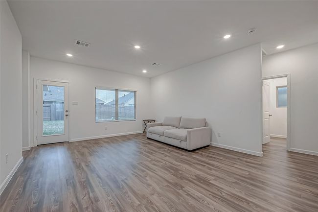 The spacious family room is bathed in natural light, thanks to its bright, airy windows, creating a warm and inviting atmosphere. | Image 11