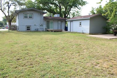 Back of property featuring a yard, a patio area, cooling unit, and an outbuilding | Image 2