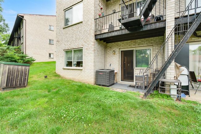 Back of house with a balcony, brick siding, and a yard | Image 18