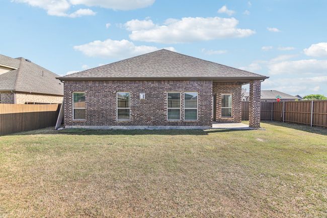 Rear view of property with roof with shingles, a lawn, a fenced backyard, and brick siding | Image 30
