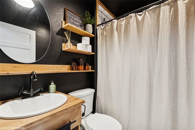 Bathroom featuring toilet, vanity, and a textured wall | Image 22