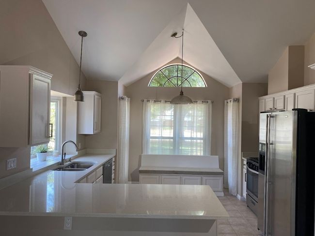 Updated kitchen with endless natural light, seating bench for morning coffee at your breakfast table, quartz countertops, and freshly painted white cabinets! | Image 4