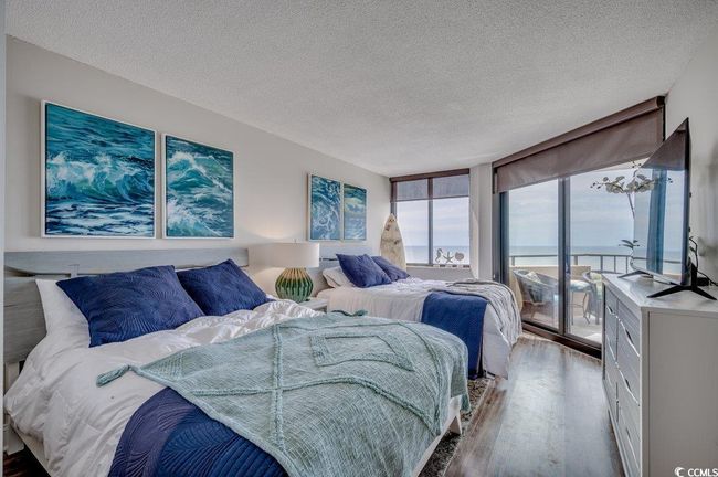 Bedroom with floor to ceiling windows, a textured ceiling, and hardwood / wood-style floors | Image 13