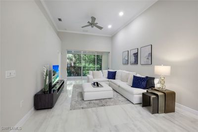 Living room with ceiling fan, ornamental molding, and a high ceiling | Image 3