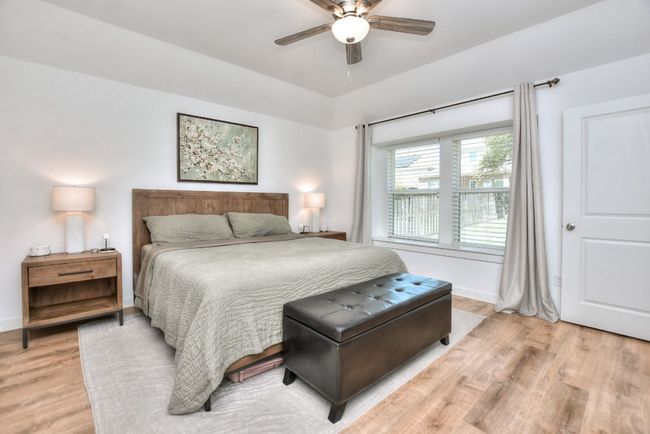 Bedroom featuring light wood finished floors, baseboards, and ceiling fan | Image 25