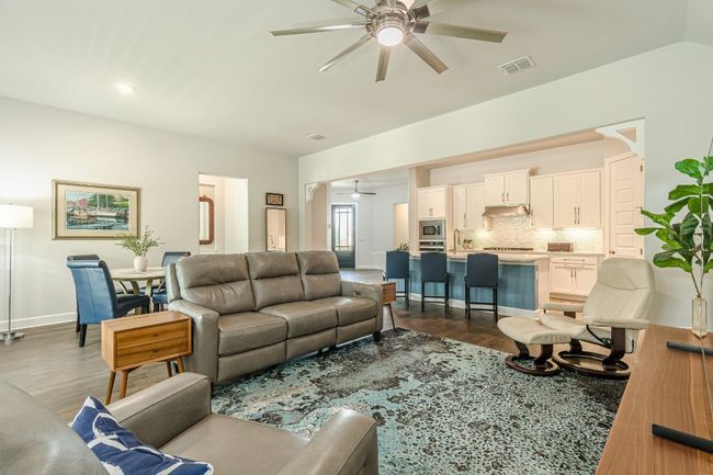 Living area with ceiling fan, dark wood finished floors, and baseboards | Image 23
