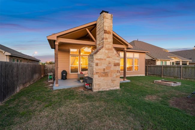 Back of house at dusk with a patio area, a chimney, and a fenced backyard | Image 33