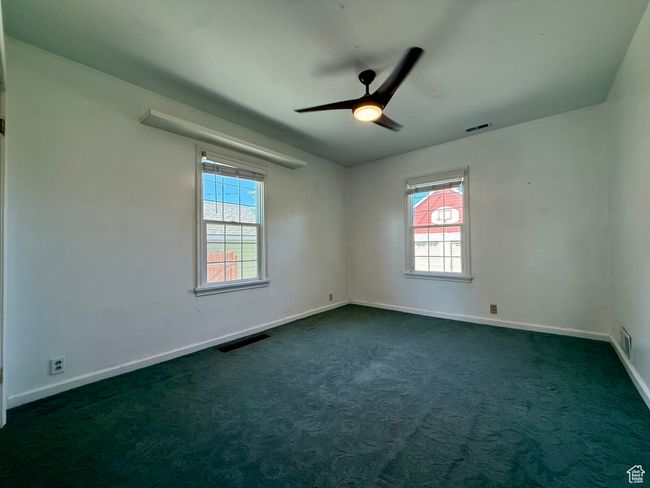 Spare room with plenty of natural light, baseboards, and dark colored carpet | Image 31