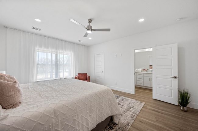 Bedroom featuring light wood-type flooring, recessed lighting, ceiling fan, and ensuite bath | Image 12